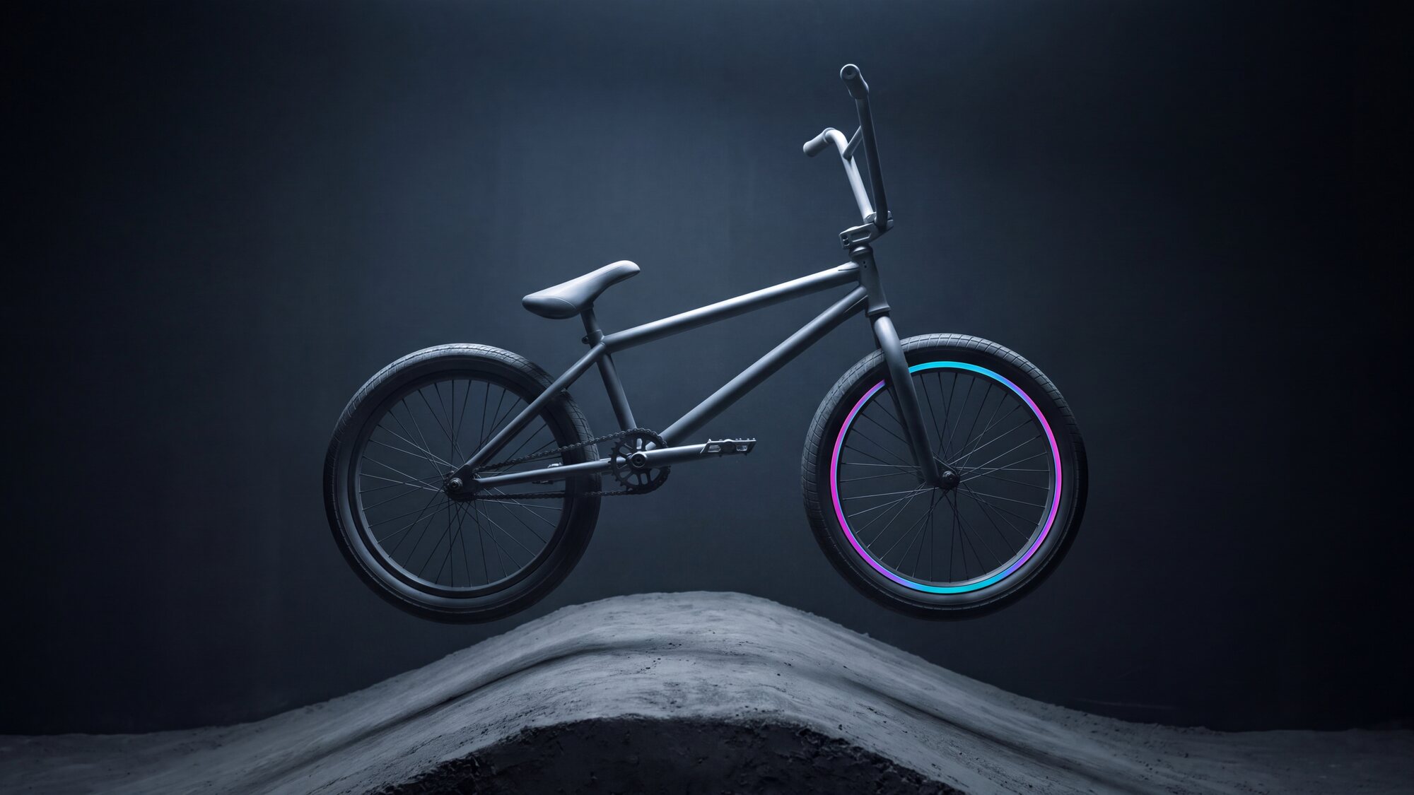 Illustrazione: una BMX con ruote da 20 pollici sospesa a mezz'aria sopra un dosso di terra battuta, controluce